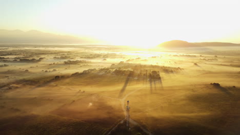 sun rising over the mountains with mist hovering over the ground