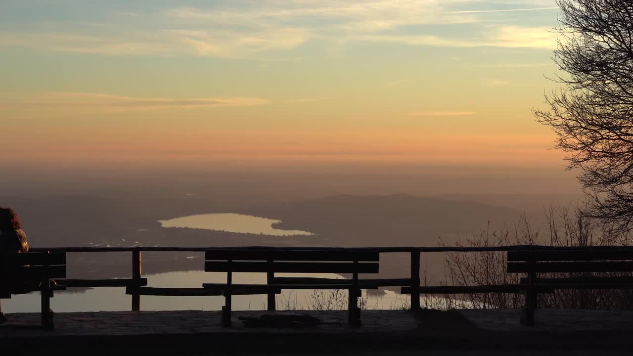 Lonely woman on bench and aerial view of campo dei fiori at dusk