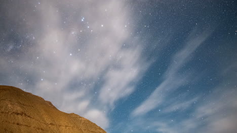 timelapse hecho de las estrellas que se mueven por encima de una montaña y rocas por la noche en chile elqui valley américa del sur con estrellas caída a través del video girando a través de las nubes en rápido movimiento