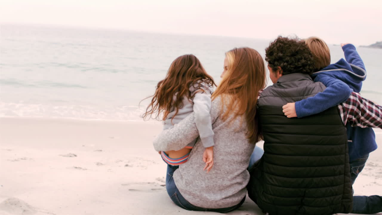 Famiglia seduta sulla spiaggia