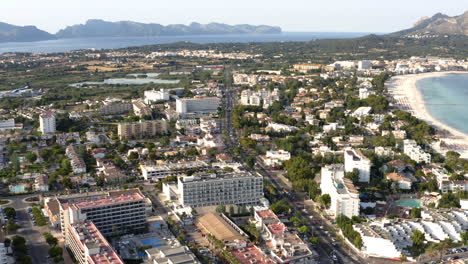 ciudad de alcudia en la costa de mallorca con tráfico de automóviles en la calle principal