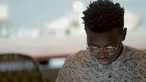 focused young man in eyeglasses working in coffee shop