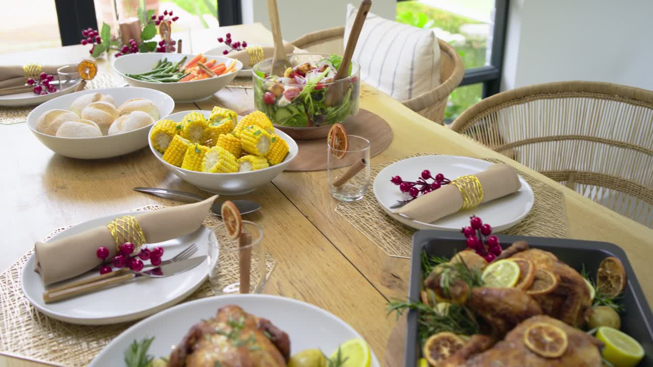 Camera starting close-up on roasted chickens and potatoes, panning holiday table showcasing feast