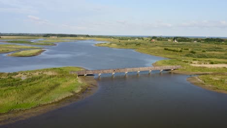 Vuelo-Aéreo-Con-Una-Bandada-De-Gaviotas-Sobre-Las-Dunas-De-Agua---Un-área-Natural-Y-Parque-Recreativo-En-La-Provincia-De-Zelanda,-Países-Bajos