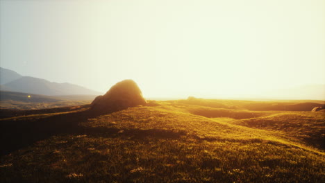 sunset over grassland with mountains in the background