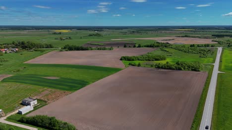 expansive farmland with fields and roads on a sunny day, aerial view