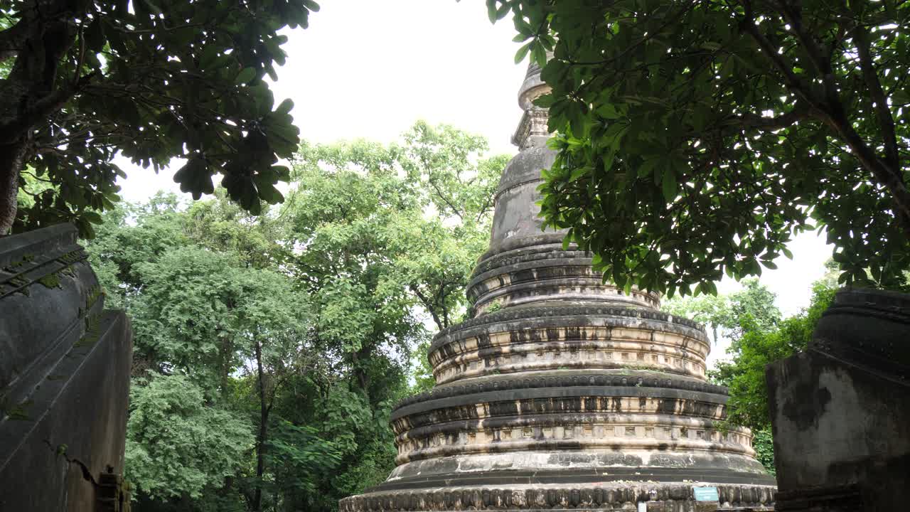 Ancient stupa at Wat Umong temple, surrounded by tropical trees in Chiang Mai