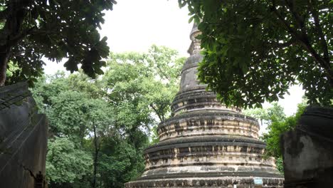 ancient stupa at wat umong temple, surrounded by tropical trees in chiang mai