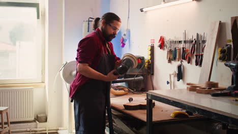 Man-with-protective-glasses-uses-orbital-sander-gear-after-consulting-schematics