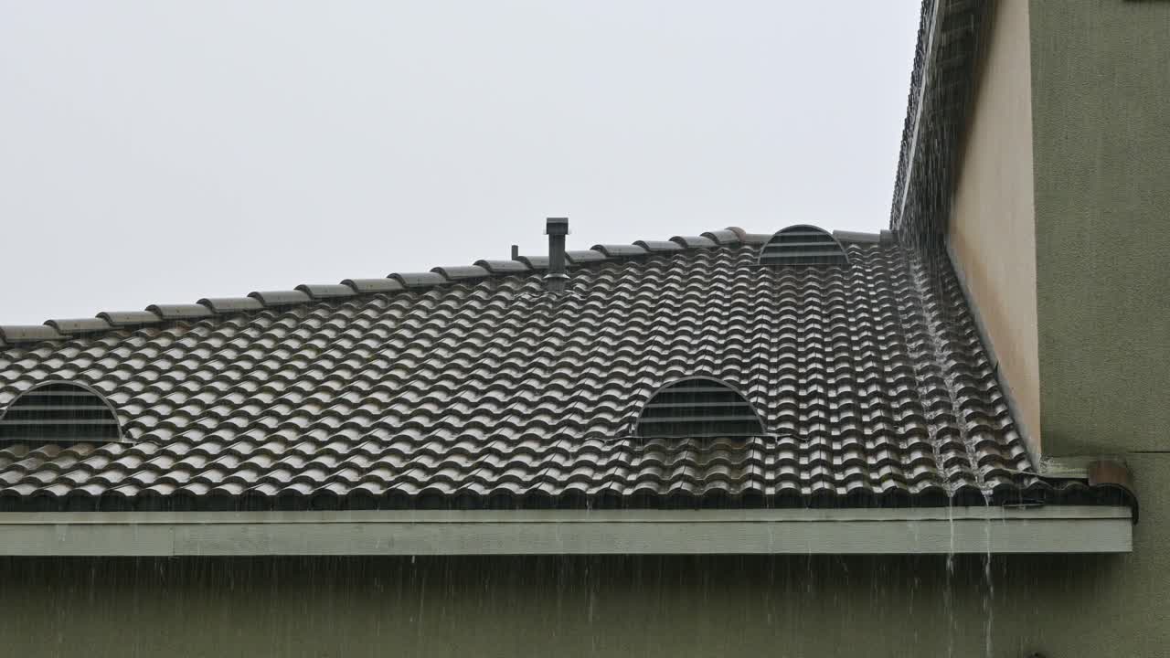 Rain falling, splashing and running off a tile roof in Southern California