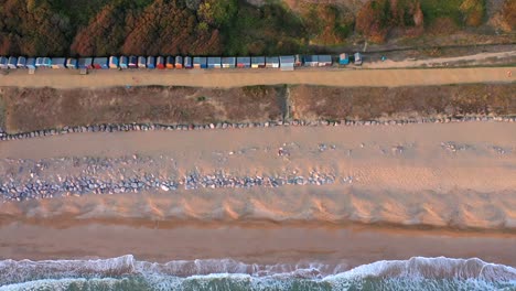 Toma-De-Drones-De-Seguimiento-De-Arriba-Hacia-Abajo-De-Barton-En-La-Orilla-Del-Mar-Al-Atardecer-En-Hampshire,-Reino-Unido