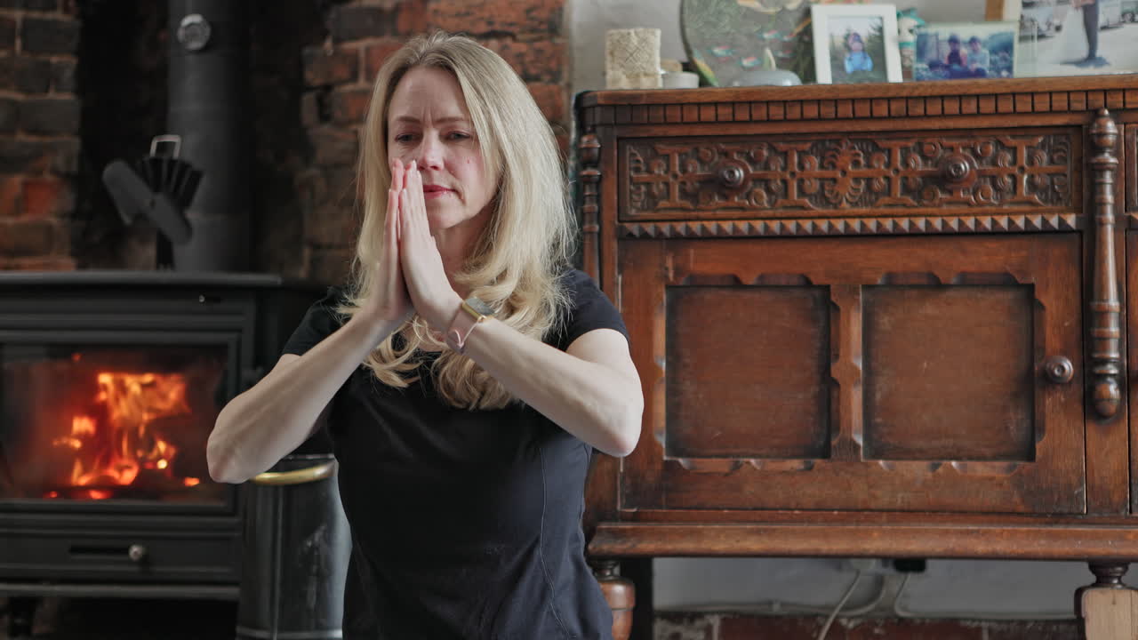 Woman practicing yoga by the fireplace