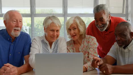 Front-view-of-active-mixed-race-senior-people-using-laptop-at-nursing-home-4k