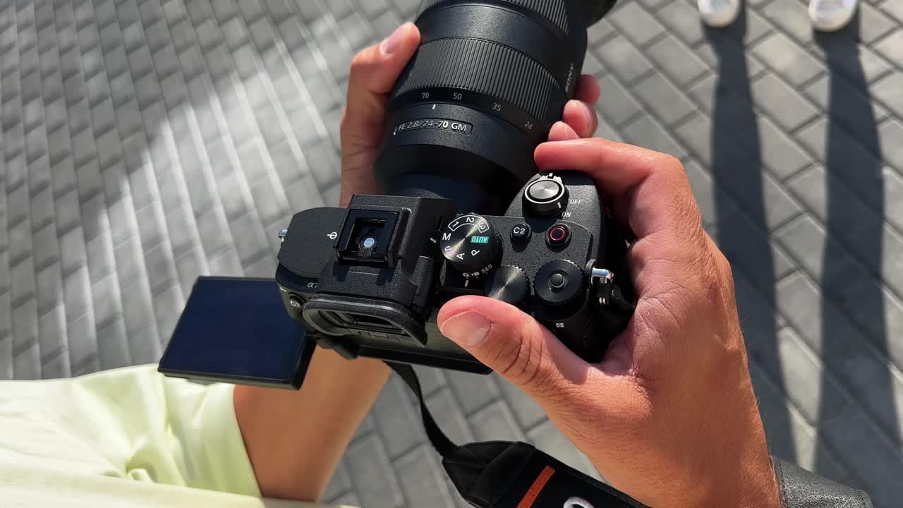 Close-up of a Sony Camera with 24-70mm Lens Held by Hands