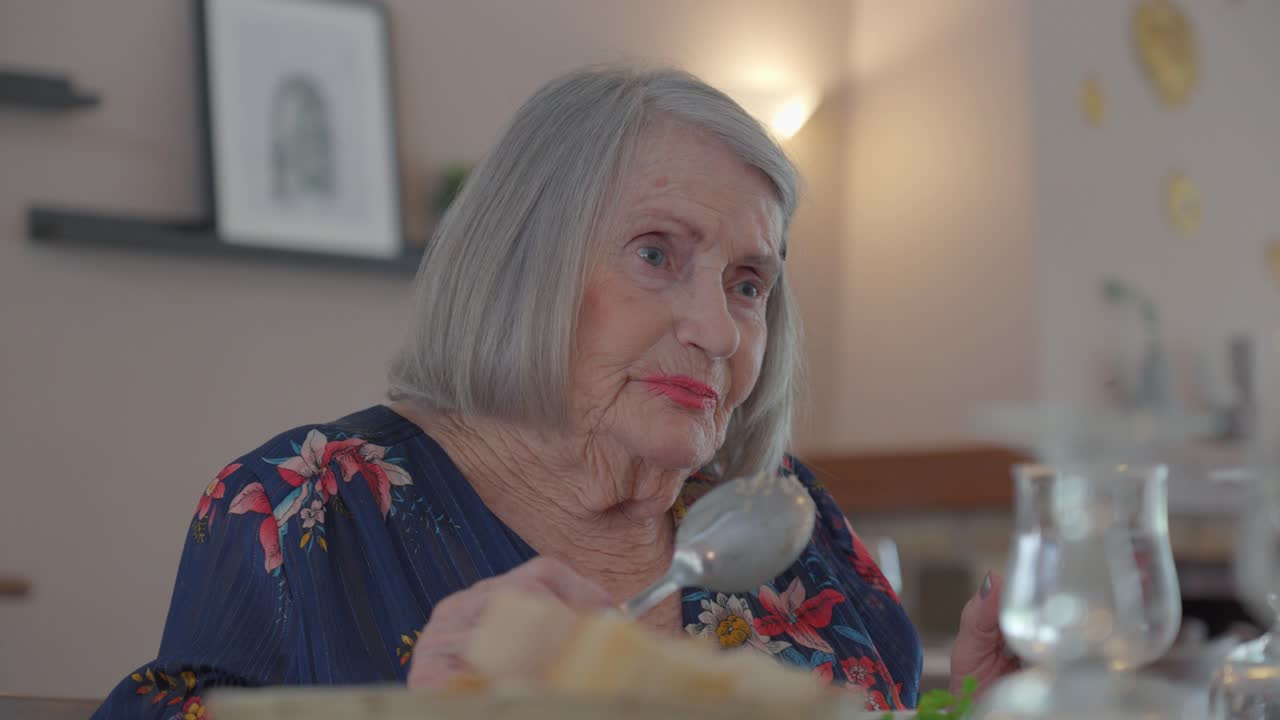 Lovely older woman tastes her dinner from her spoon, slow motion