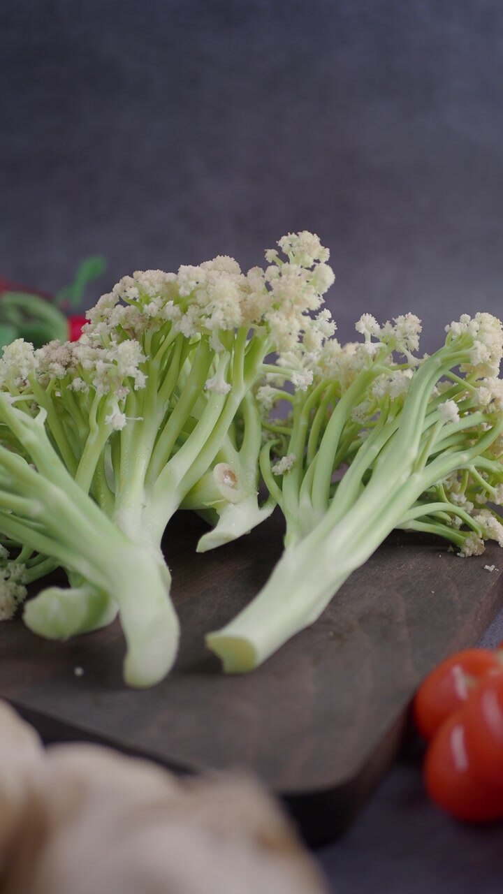 Close-up of Fresh Cauliflower Florets on a Wooden Cutting Board