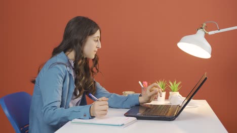 young woman looking at laptop is unmotivated and bored.