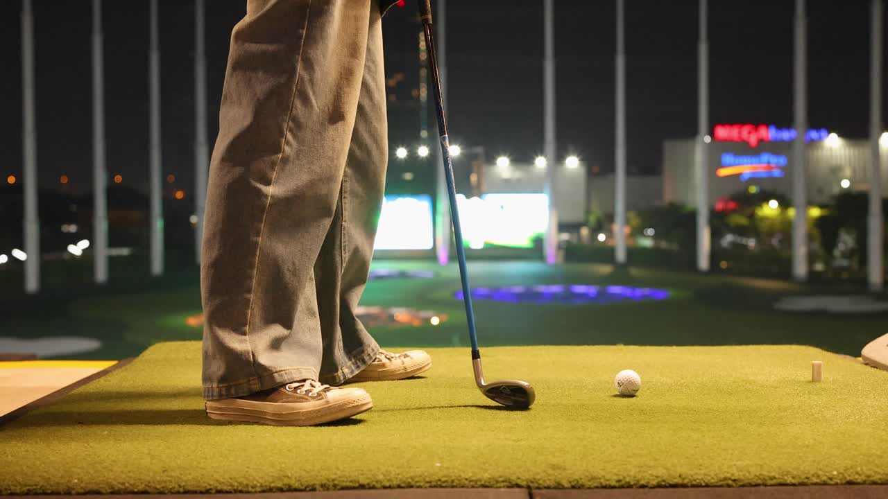 Golfista che si prepara a fare il tee shot di notte