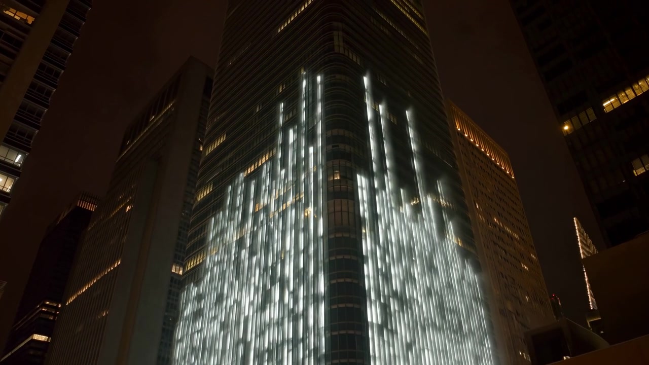 Paesaggio urbano notturno sereno con finestre illuminate e grattacieli da una prospettiva drammatica dal basso, architettura moderna in vetro e metallo, toni blu scuro e gialli, ambiente urbano sereno