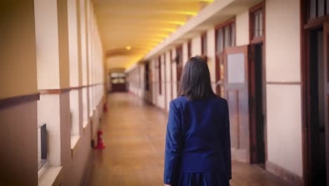 High-school-Student-walks-down-long-corridor-in-slow-motion,-Japan