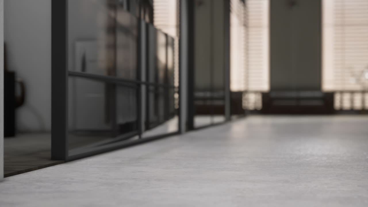 Light spills across a concrete corridor in a modern building during daytime