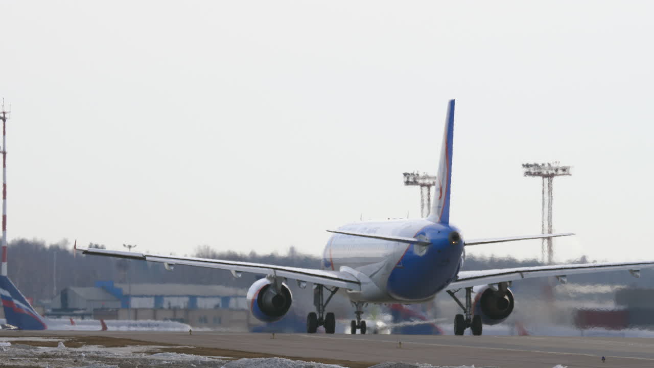 una vista trasera de un avión moviéndose en un patio del aeropuerto