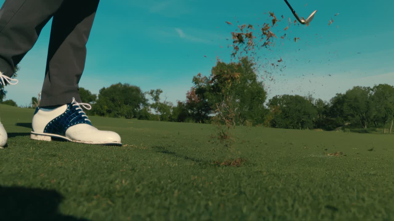 Slow motion golf shot from side, wedge shot from clean fairway lie on sunny day in 4k push in