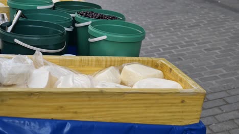 outdoor market stall with cheese and olives