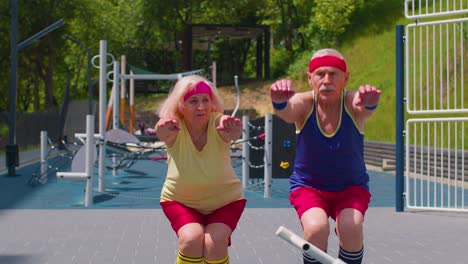 hombre anciano mujer haciendo entrenamiento activo estirando los músculos agachándose ejercicio de fitness en el patio de recreo