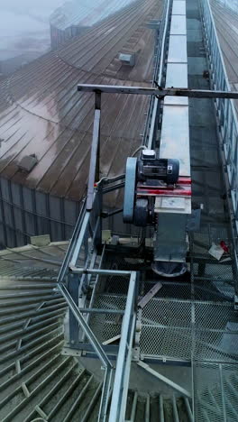 metal passages between the huge tanks of grain elevator. number of granary elevator cisterns standing close to each other at agribusiness plant. vertical video