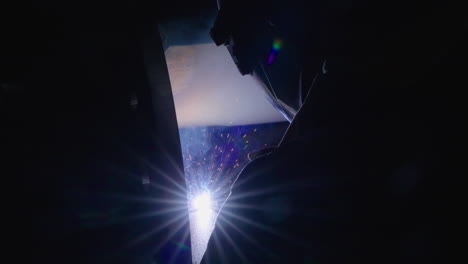 man wearing protective gear welding a metal beam slow motion medium shot