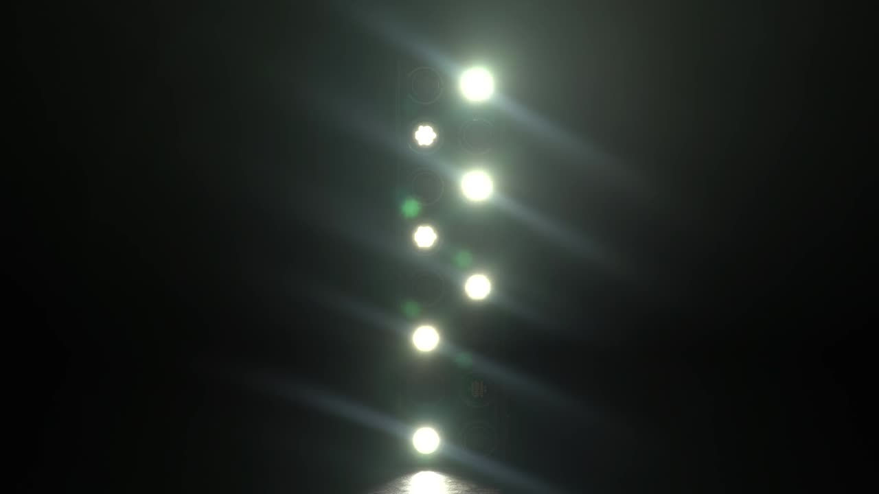 conjunto de luces de concierto parpadeando y moviéndose en el escenario