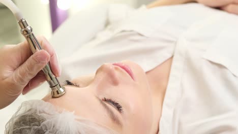 footage of masseur standing by massage table with brunette in spa young woman resting during. footage of masseur standing by massage table with brunette in spa. young woman resting during procedure. atmosphere of relaxation. healthcare concept. indoors