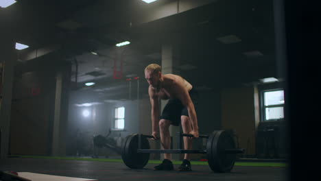 one man lifting heavy weights in gym. romanian deadlifts with a barbell in gym in slow motion