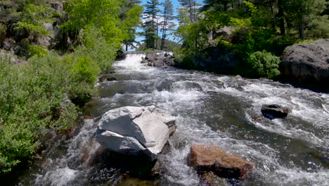 agua rápida fluye alrededor de una roca de granito blanco en rápidos de río, fijada en 4k 60fps