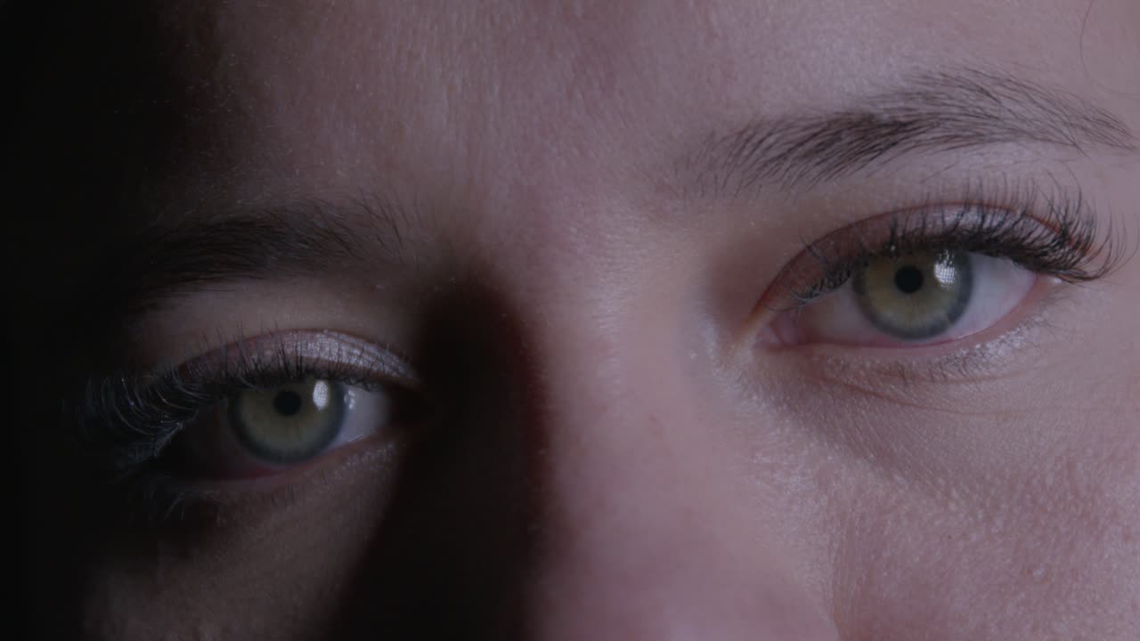 Intimate close-up of a girl's eyes, conveying a soft expression. Subtle lighting enhances the gentle mood, with a focus on detail and texture