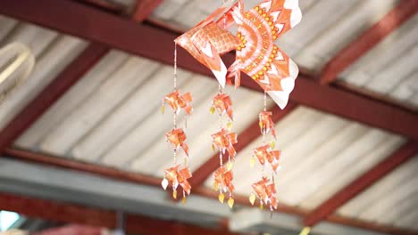 fish-shaped mobile swaying under a roof