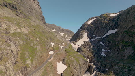 Old-mountain-pass-along-rugged-valley-with-patchy-snow---Roldalsfjellet