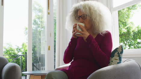 Mujer-Caucásica-Mayor-Tomando-Café-Mientras-Está-Sentada-En-El-Sofá-De-Casa