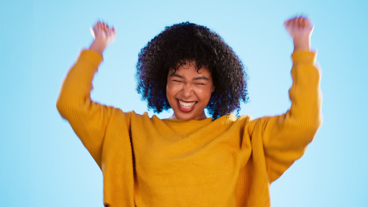 Yes, winning and happy woman isolated on blue