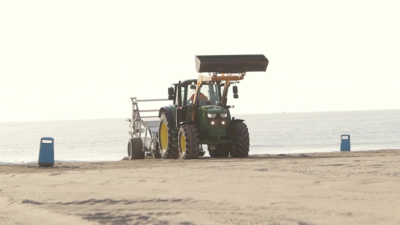 Macchina su ruote che pulisce una spiaggia in Spagna