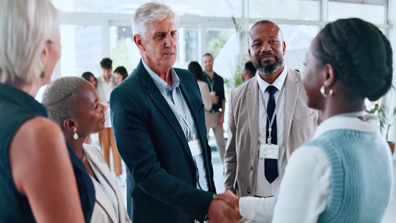 Professionnels d'affaires diversifiés se serrant la main et réseautant lors d'une conférence
