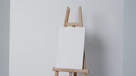 video of white canvas sign on wooden easel with copy space on white background