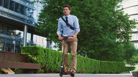 businessman commuting to work through city on scooter