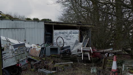 Cat-on-roof-of-abandoned-house-with-trash-around,-handheld-wide