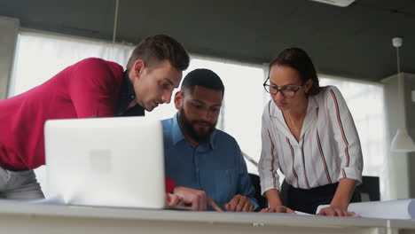 young people comparing information between laptop and document