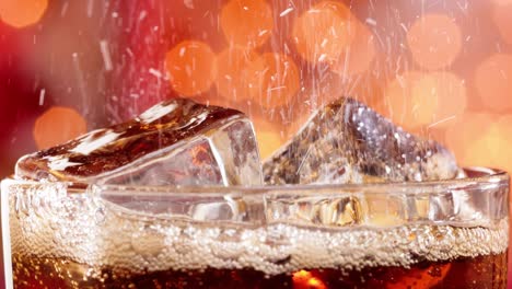 un vaso de cola. cola helada con burbujas salpicando cámara lenta en una luz borrosa, fondo borroso.