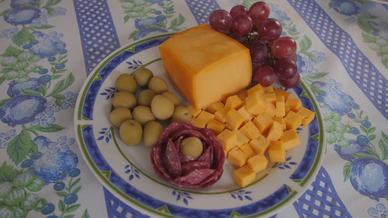 trozos de queso y fruta y uvas en un plato en la mesa