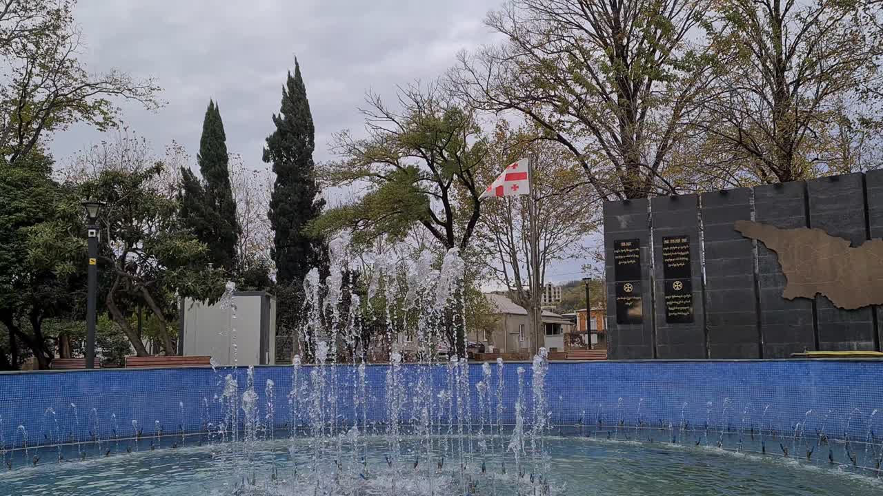 Georgian flag next to fountain in park in georgia