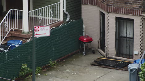 street cleaning-no parking sign waves in the wind during a rainstorm in the summertime